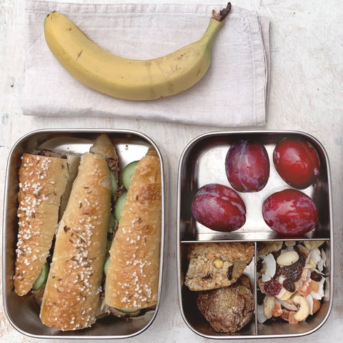 Bento Large 1 i rustfrit stål 18/8 med baguettesandwich, blommer og nødder ved banan fra Yummii Yummii